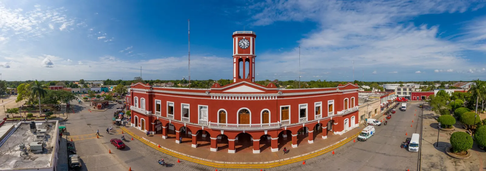 Edificio colonial rojo con torre de reloj en el centro de Motul