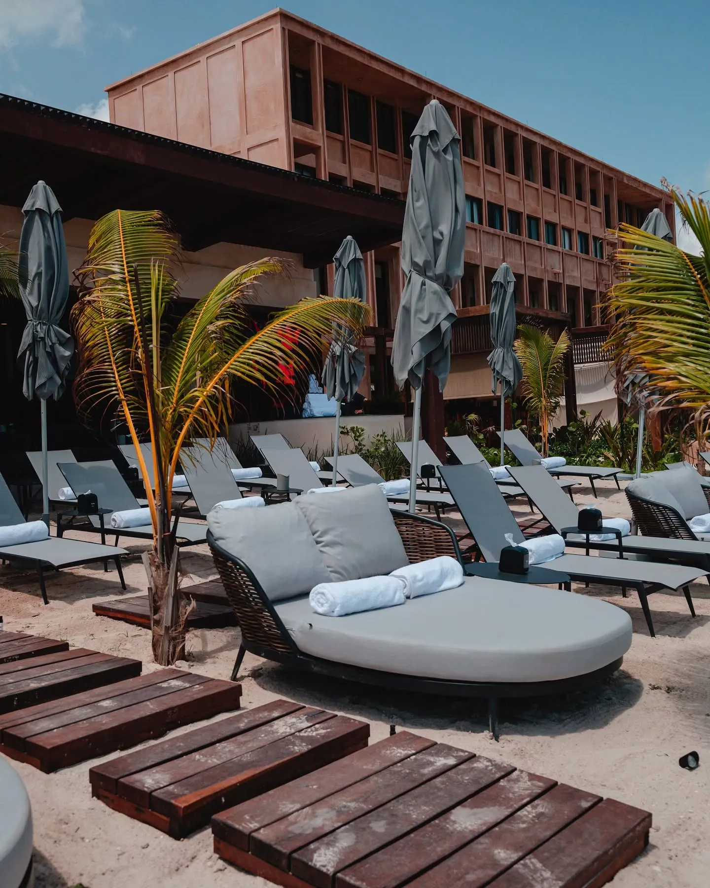 Camas de playa y camastros premium frente al edificio de Playaviva Beach Club